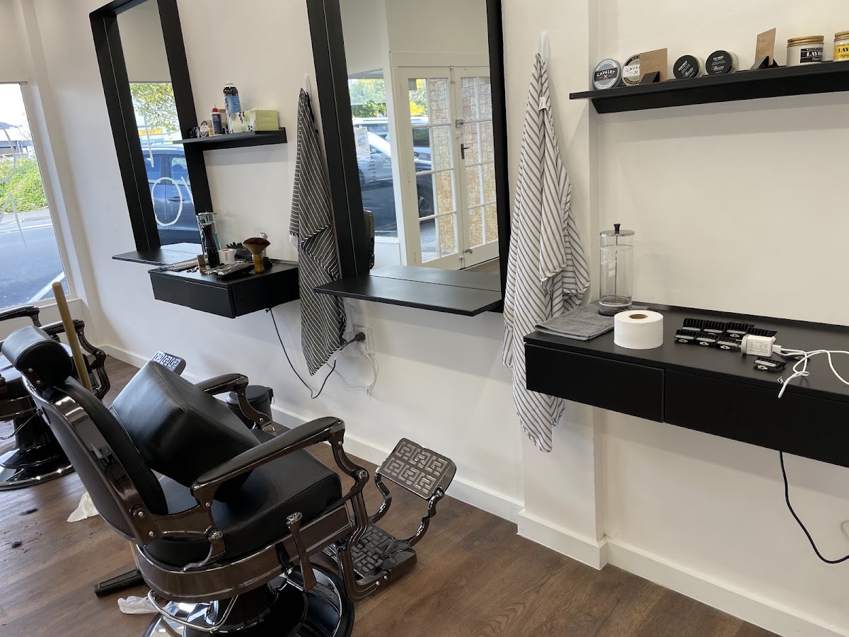 Barber stations with striped capes and product shelf