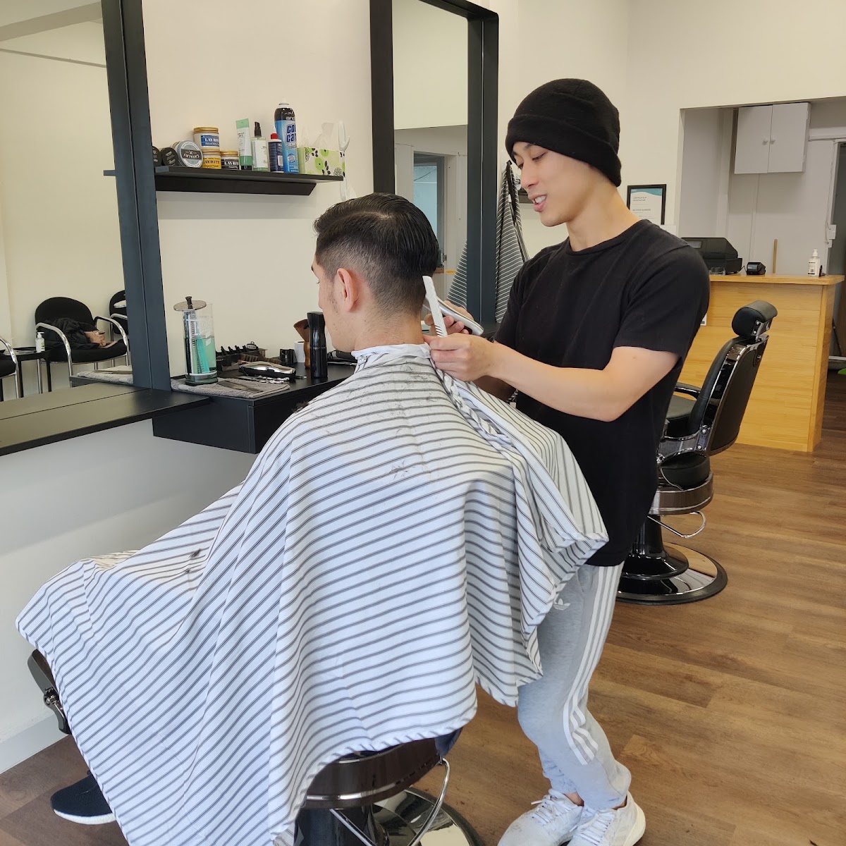 Barber working a comb and clippers through a client's fade