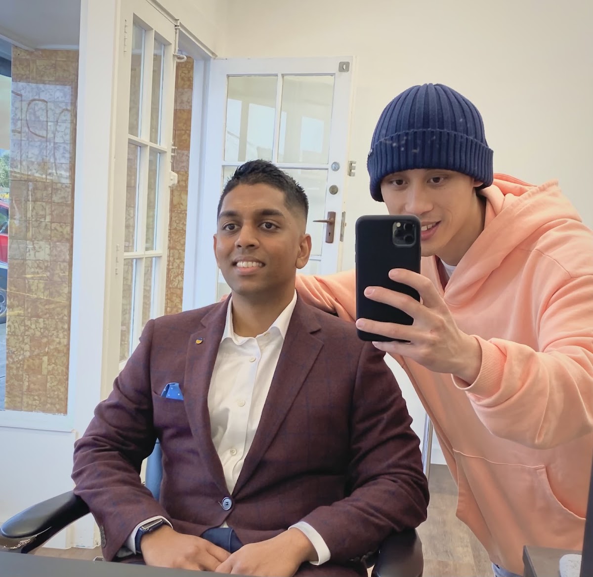 Barber and a happy suited customer checking the finished cut in the mirror